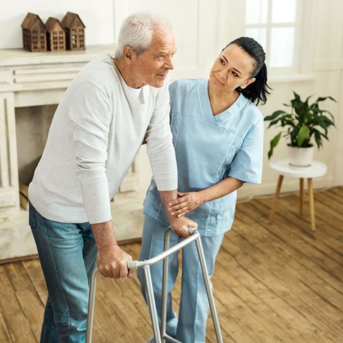 Austin Senior Living | Senior man walking with the help of a caregiver